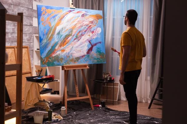 Homme qui peint une toile